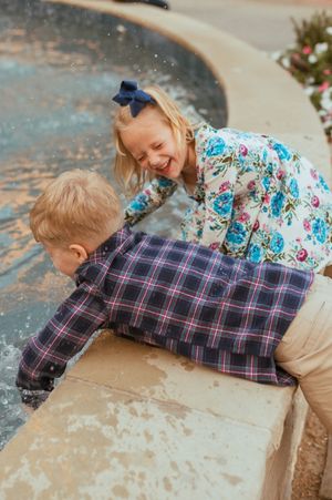 Children lay playfully on a concrete surface while enjoying a fun moment together.