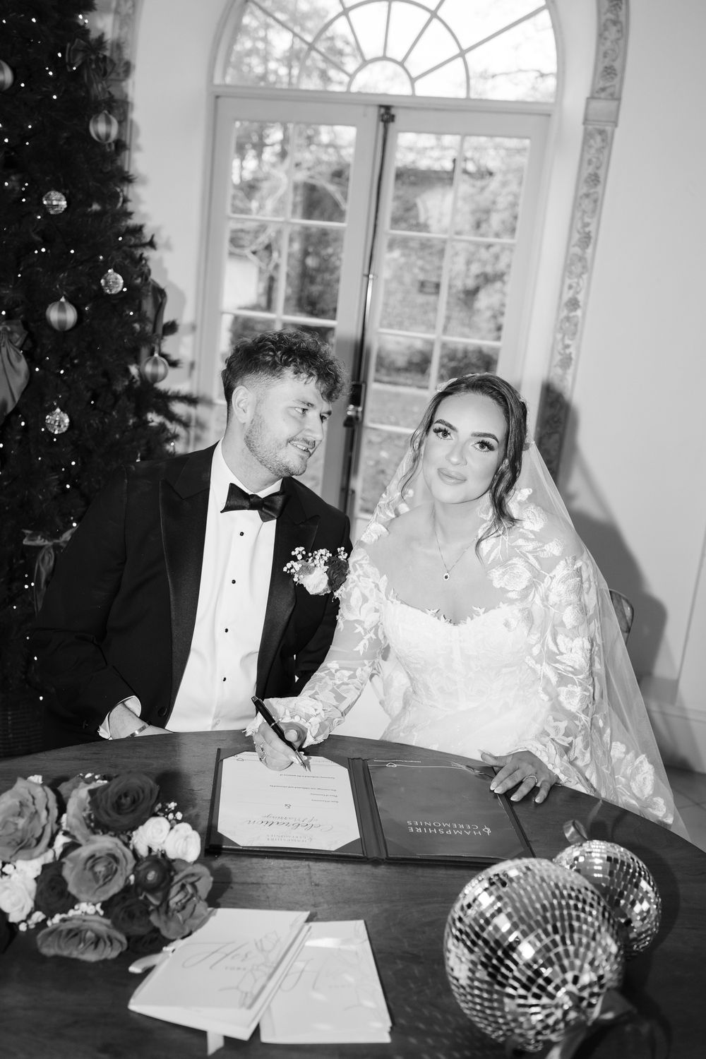 A black and white photo series of a bride and groom sitting together at a wedding reception table.