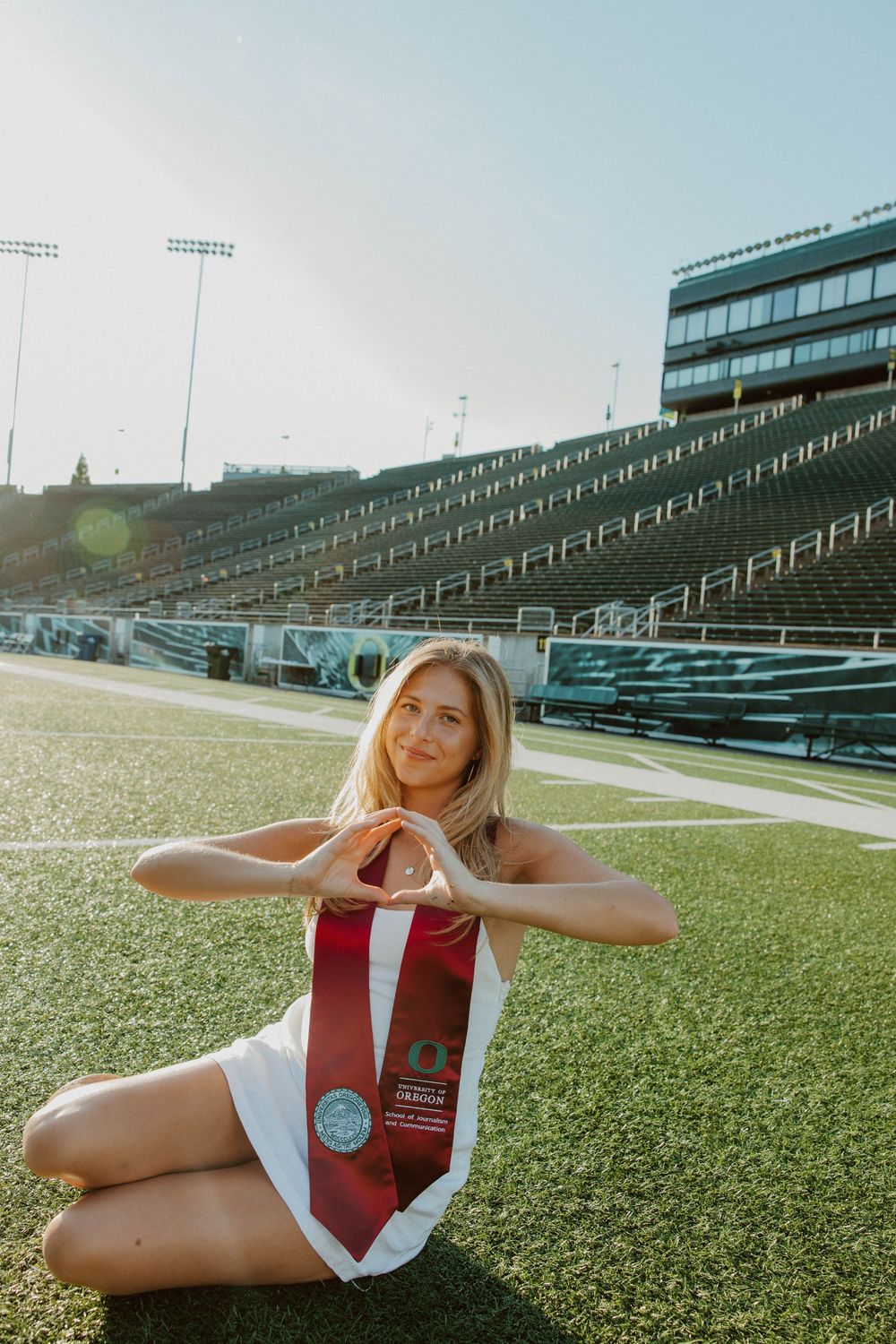 Athletic photo shoot on football field with stadium seating in background.