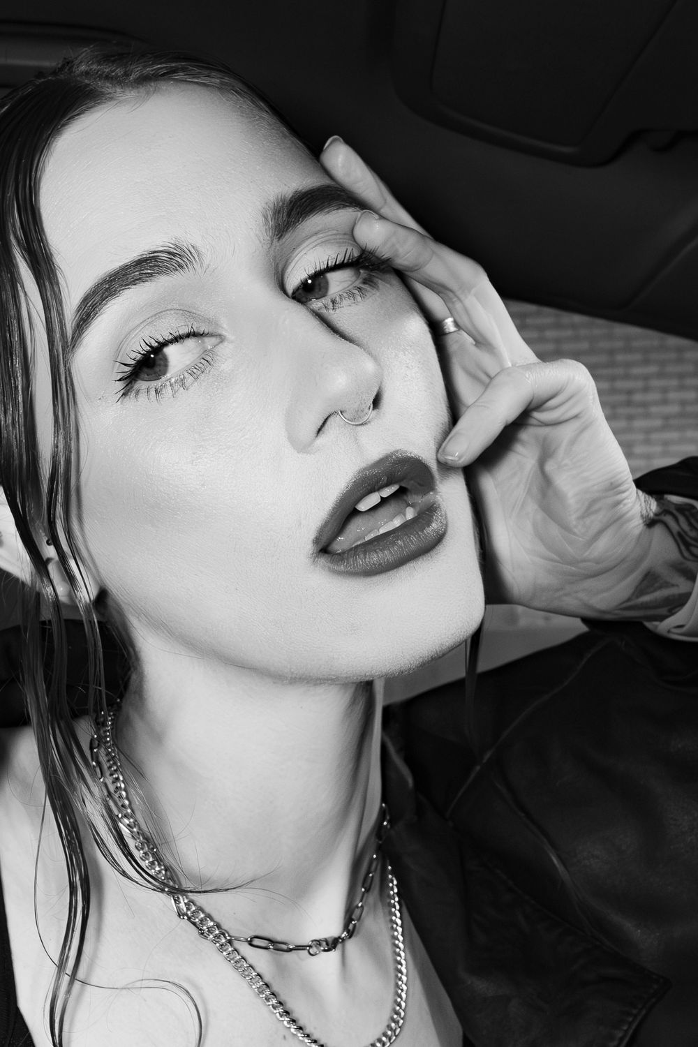 Close-up selfies in car showing jewelry and dramatic makeup in black and white.