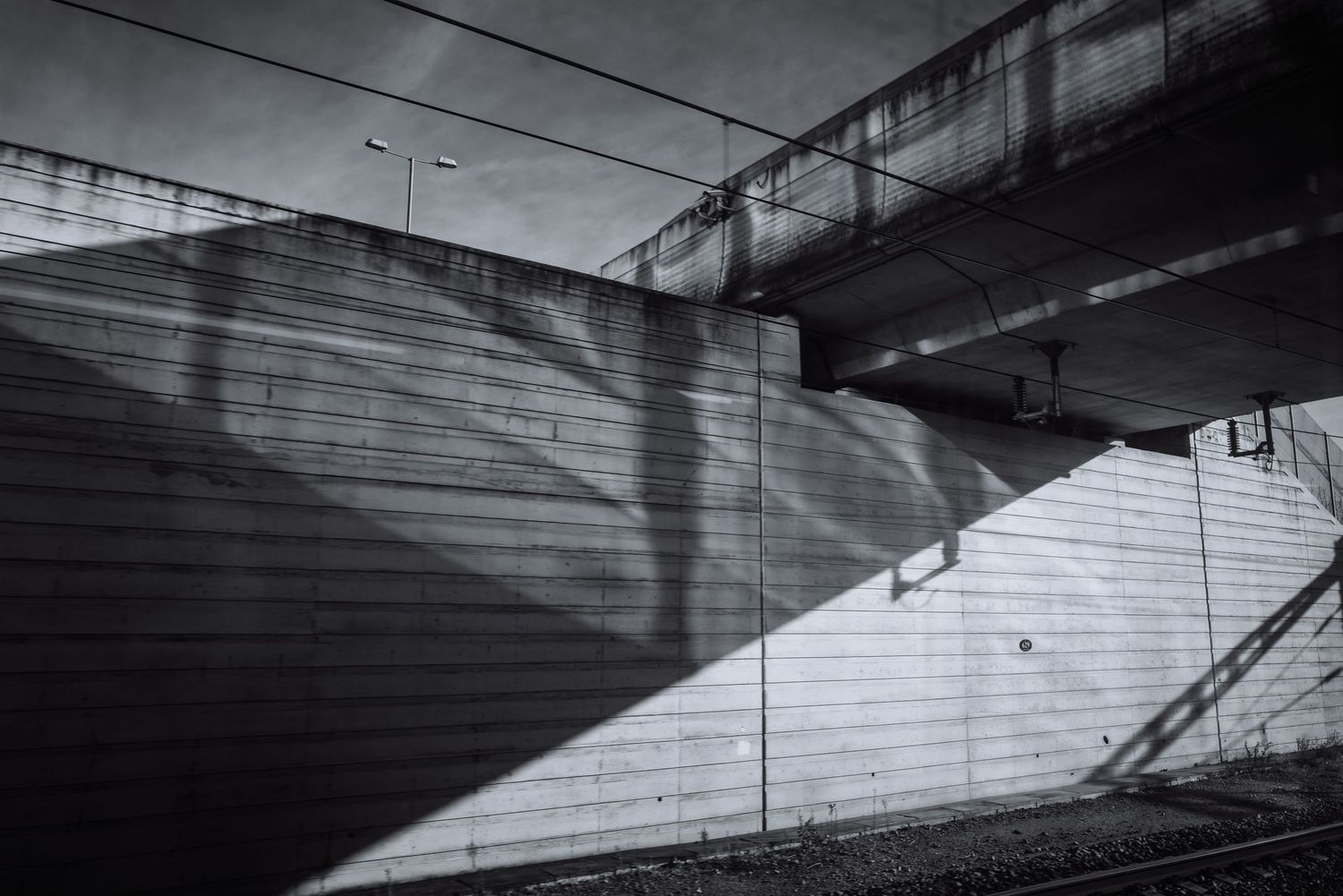 Abstract geometric patterns formed by concrete bridge structures viewed from below.