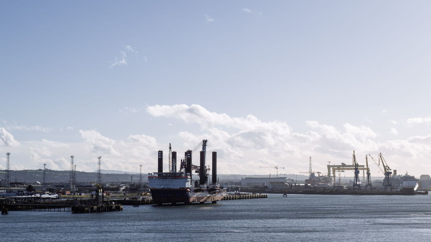 Panoramic view of industrial port facilities and ships along the coastline.