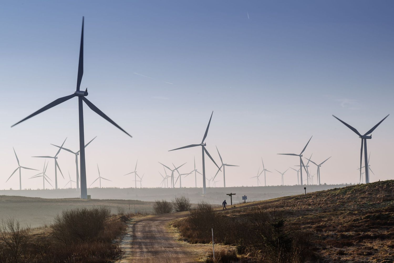 Wind turbines dot the horizon across a vast open landscape.