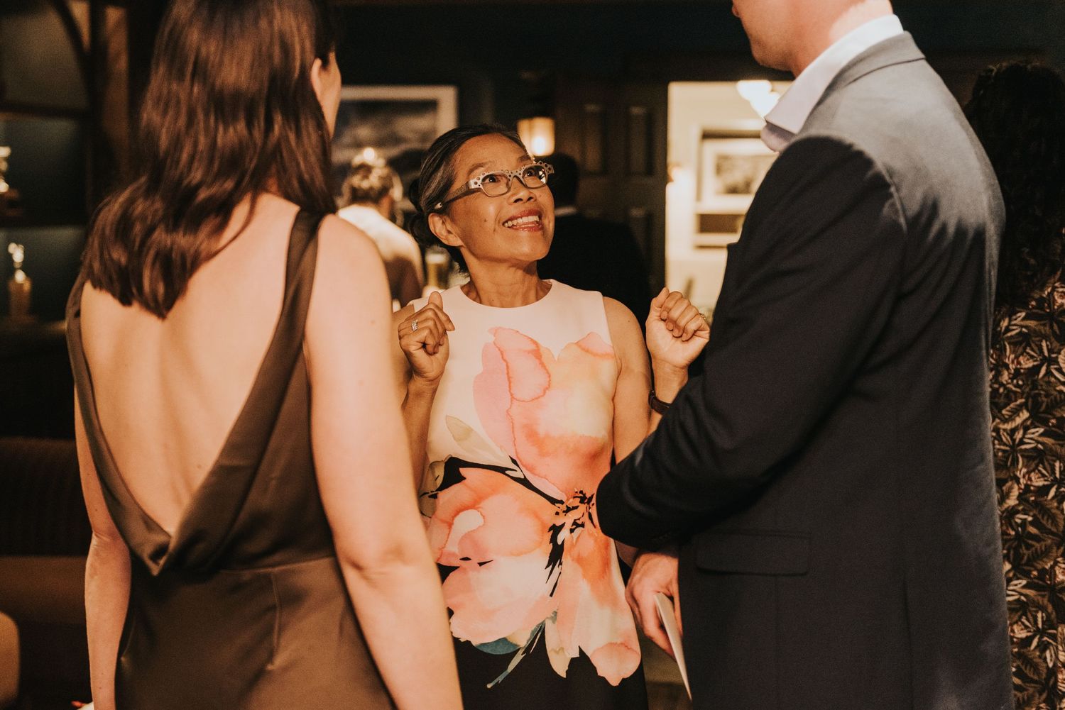 A couple shares an intimate dance moment at a wedding reception with guests watching in the background.