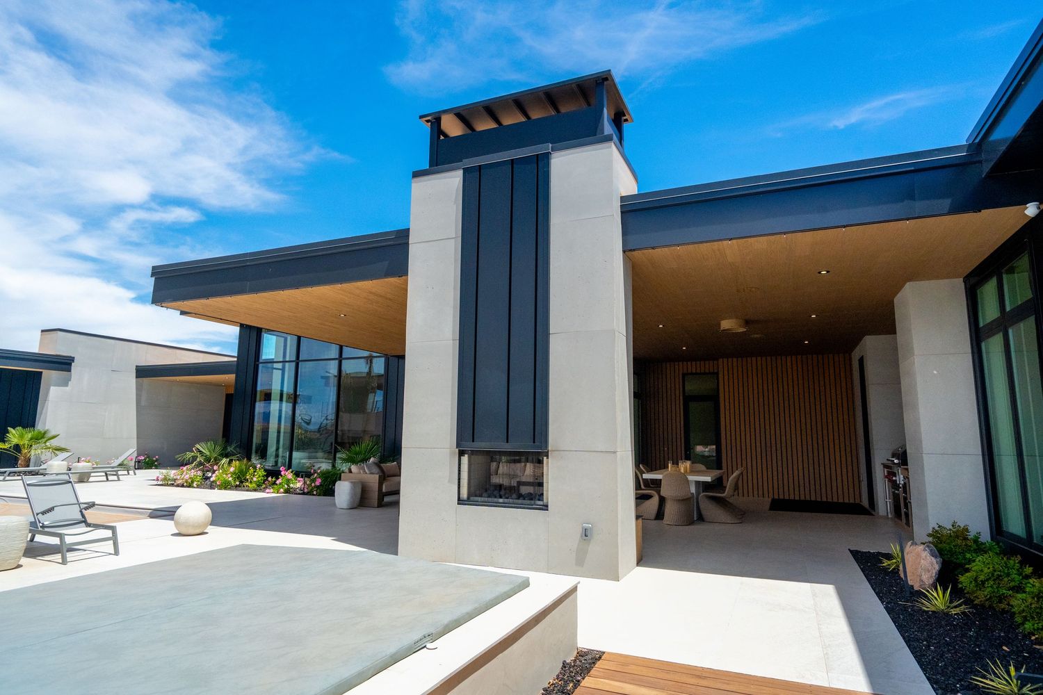 Modern architectural building features clean lines and overhanging roof elements against a bright blue sky.