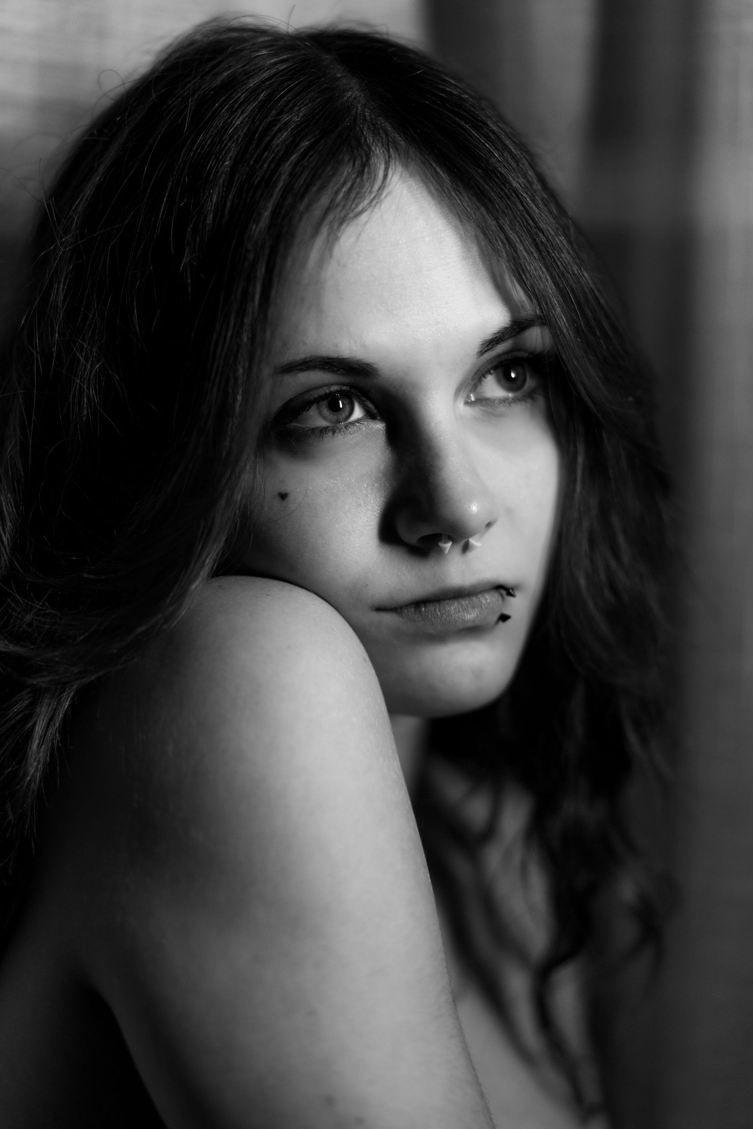 A black and white portrait series showing close-up artistic angles of a person with dark hair against a moody background.