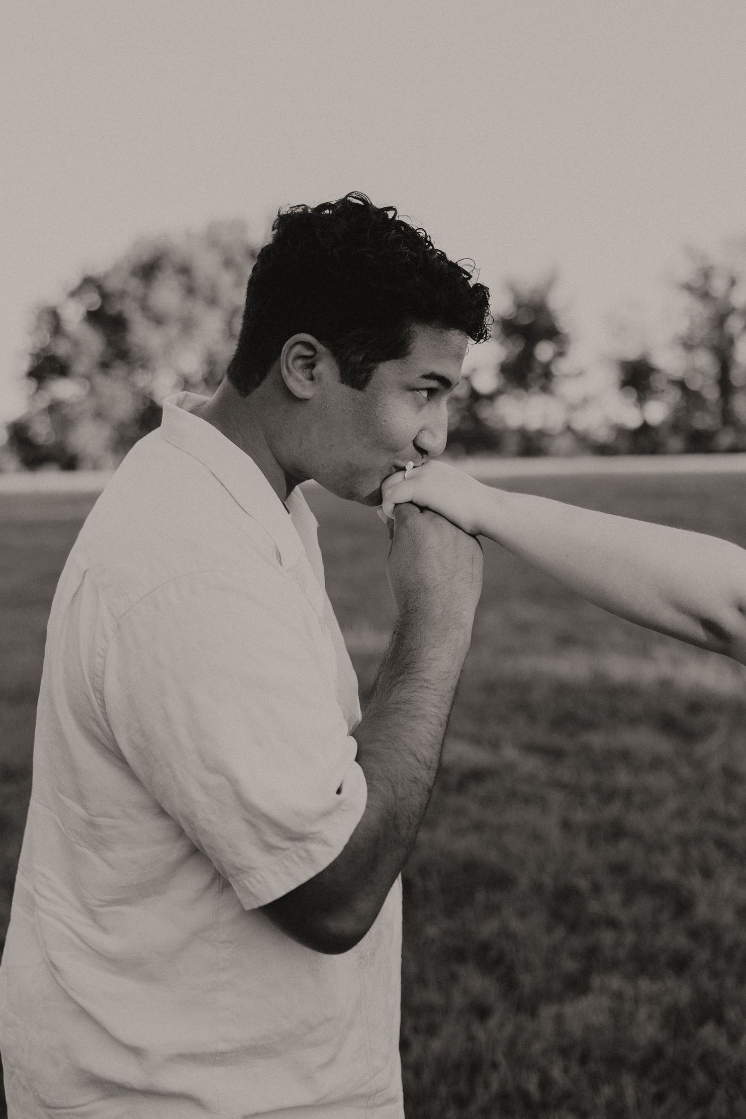 A person in a white shirt stands in a grassy field taking photos in a sequence of four connected images.