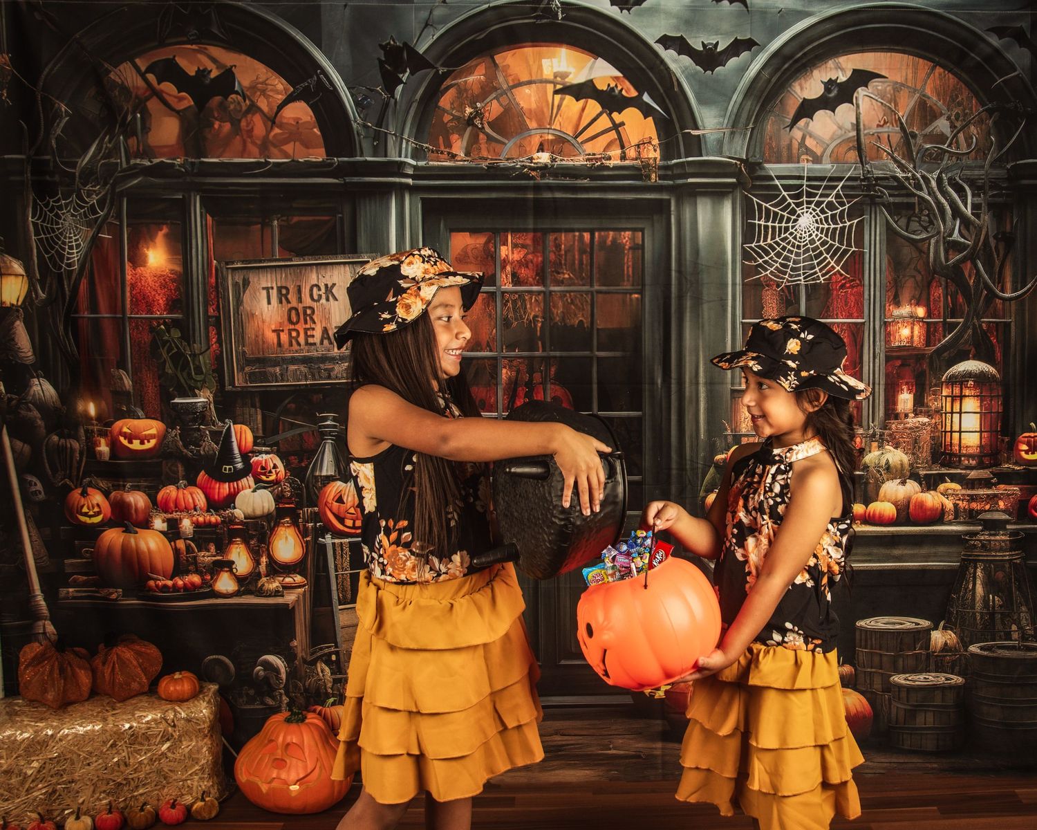Halloween themed photoshoot with pumpkins and gothic arches in orange and black tones.
