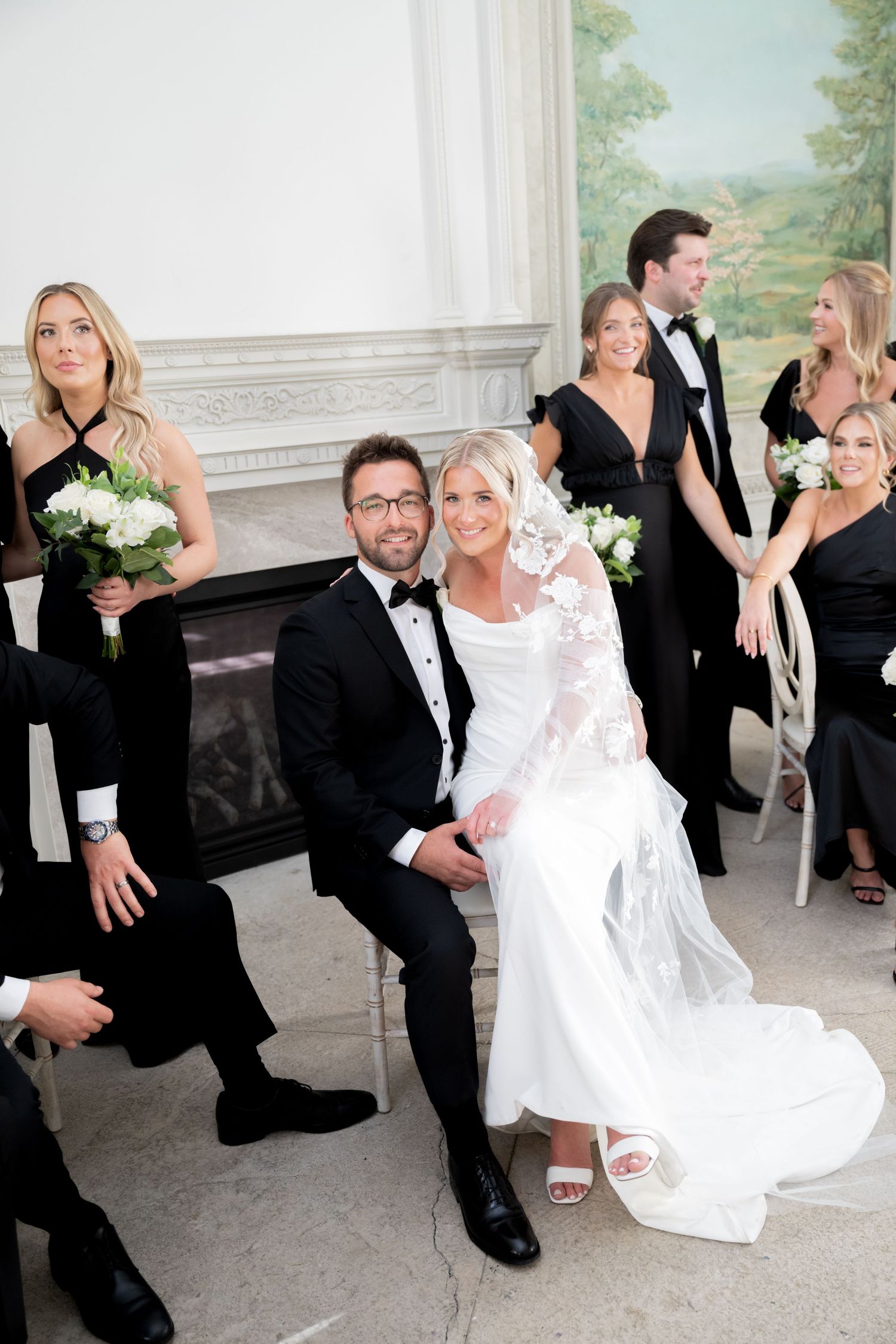 Wedding party members perform a choreographed dance routine in formal attire at an elegant venue.