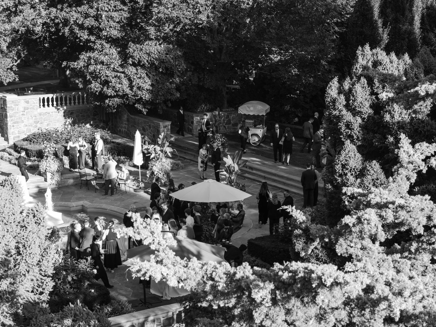 Black and white aerial view of a cemetery with headstones and trees creating a peaceful memorial landscape.