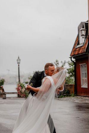 Brudpar kysser varandra på södermalm i stockholm i regn