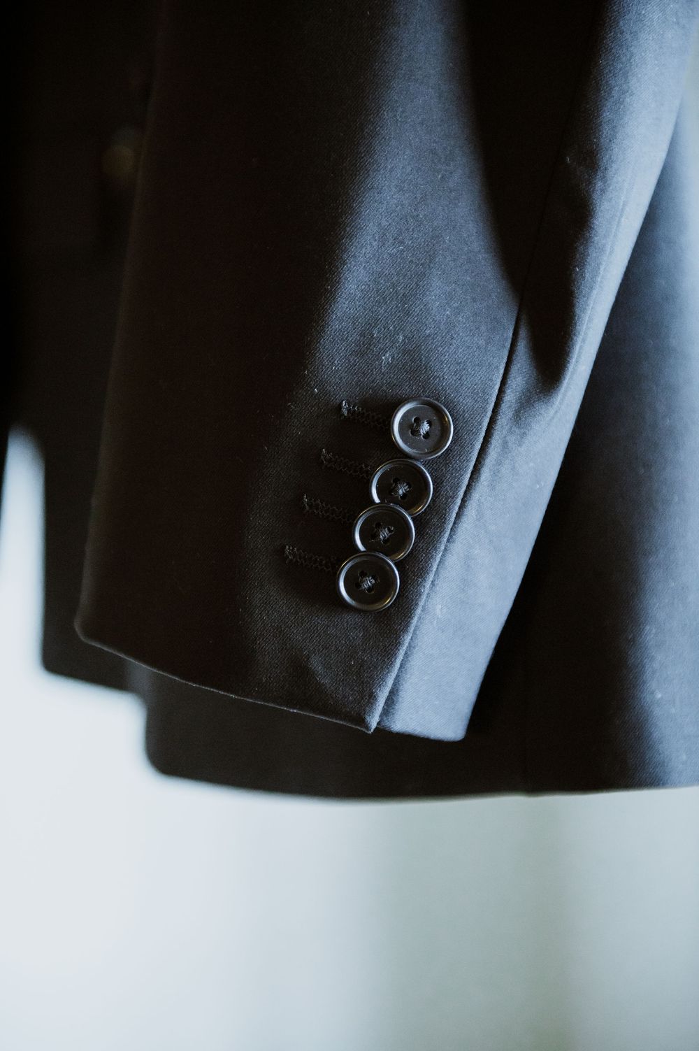 Close-up macro shots of suit jacket sleeve buttons showing fine tailoring details.