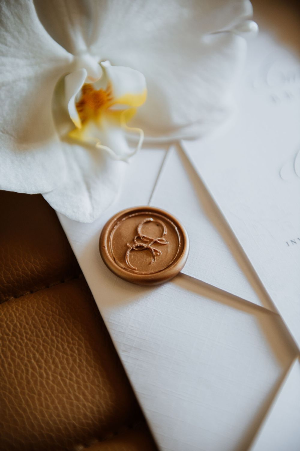 White paper with gold wax seal stamp showing elegant branding detail.