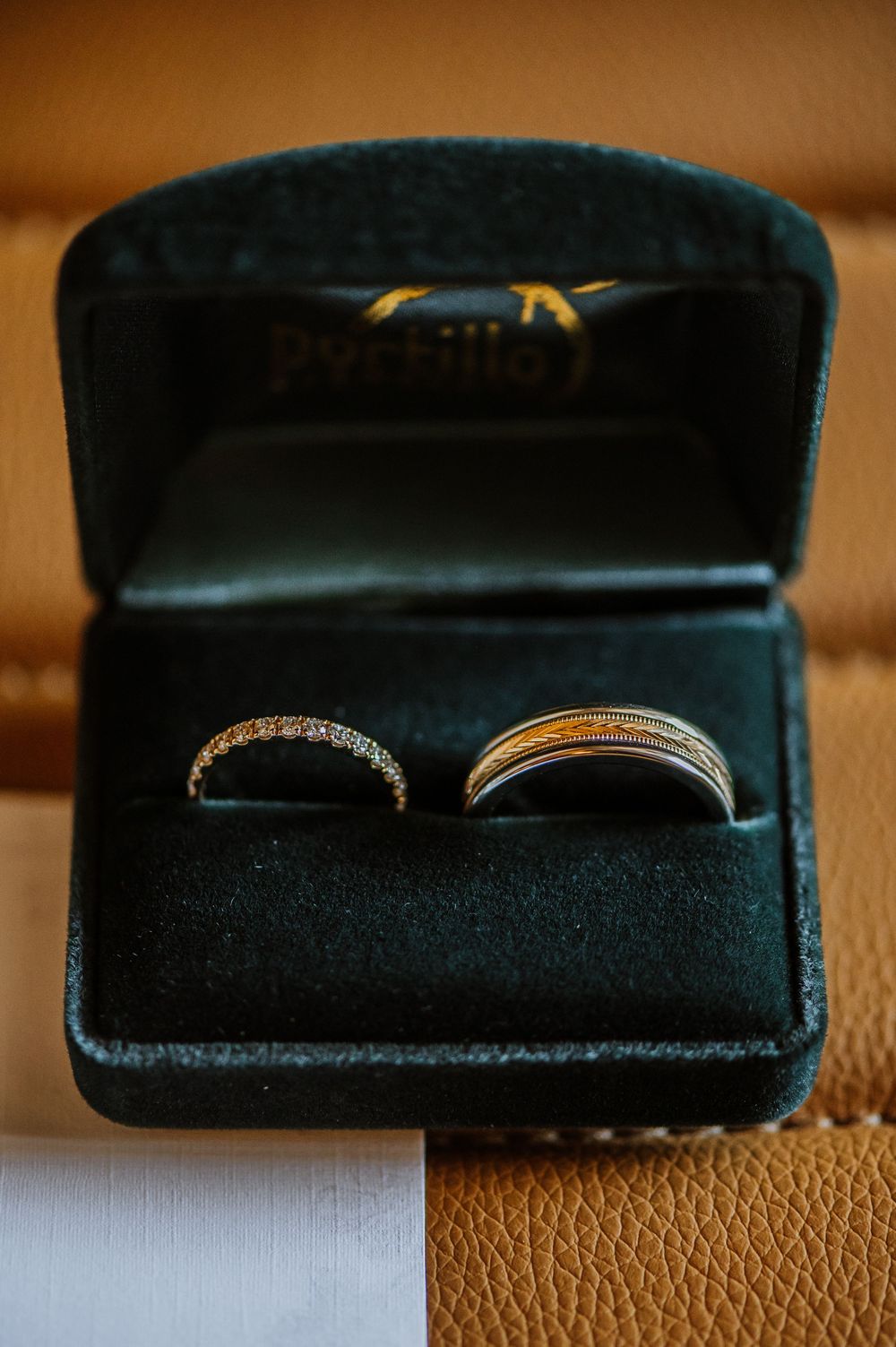 Wedding rings nestled in black velvet jewelry boxes shown from different angles.