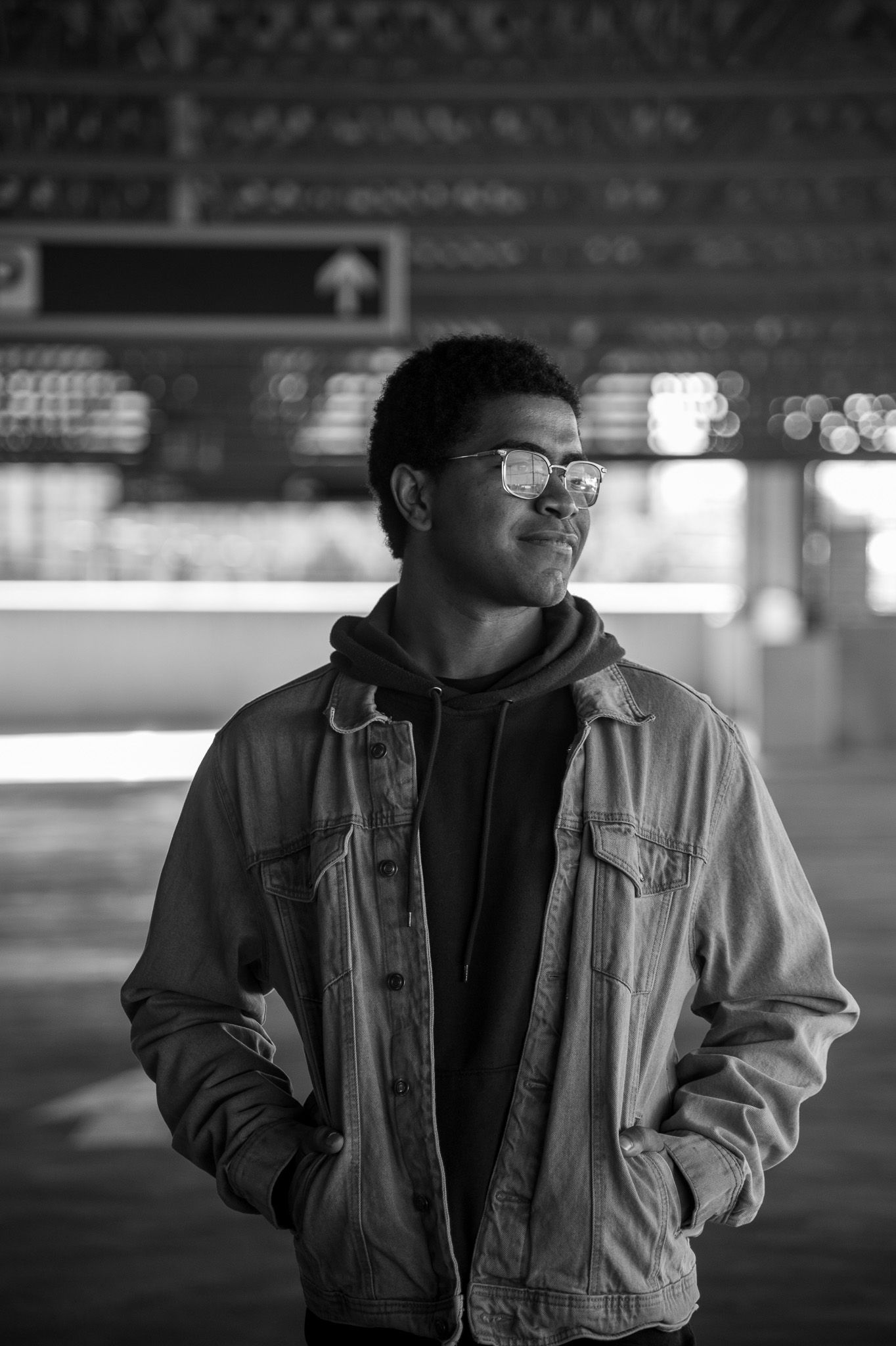 Black and white photo sequence of a person in casual wear posing against a dark background.
