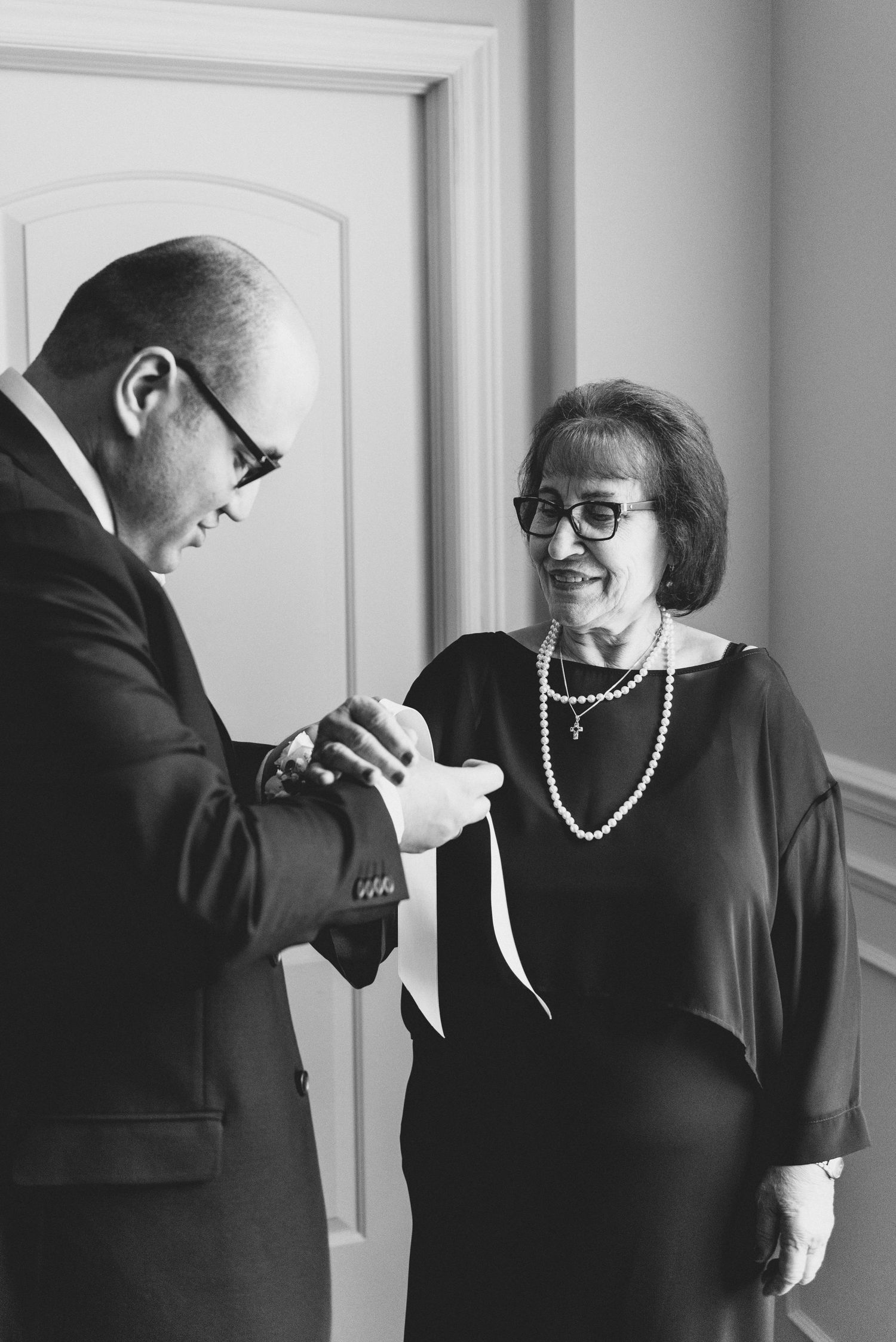 A series of four black and white photos showing two people in formal attire interacting in an intimate conversation.