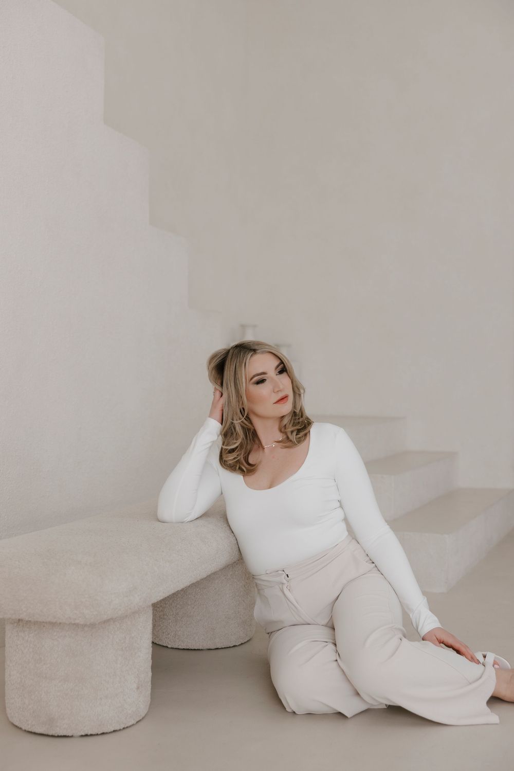 Lifestyle photography featuring cream-colored loungewear and textured floor cushions in a minimalist setting.