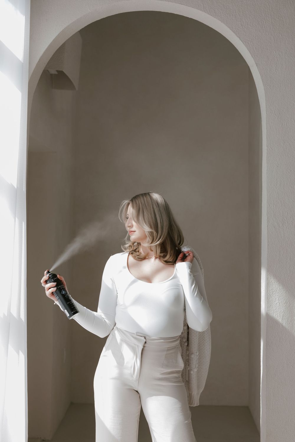 Modern fashion photography series in white arched hallway with natural lighting.
