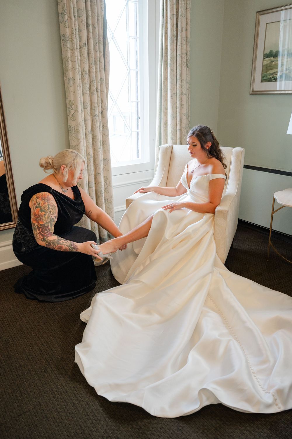 A series of photos showing a person in a black dress helping adjust a flowing white wedding gown on a carpeted floor.