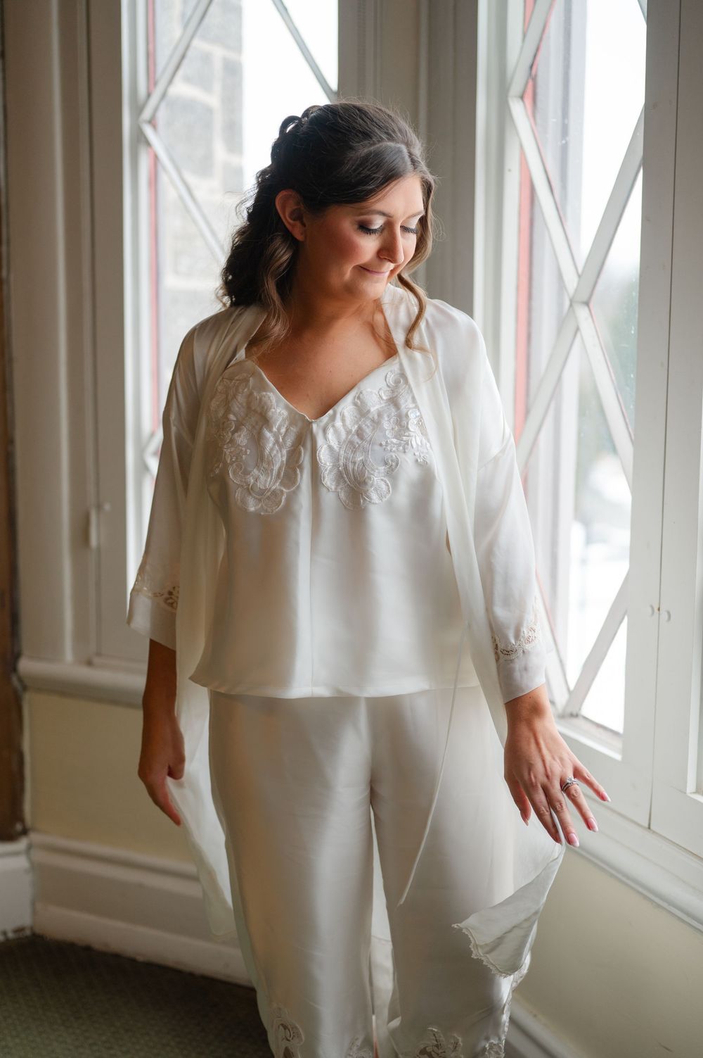A bride wears custom getting ready pajamas made from her mother's wedding dress.