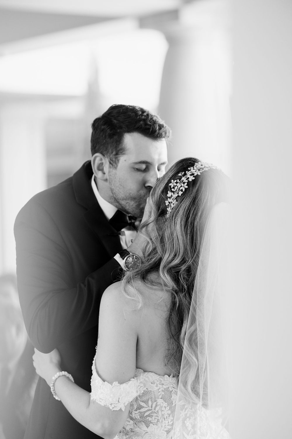 Romantic black and white wedding portrait in elegant venue setting.