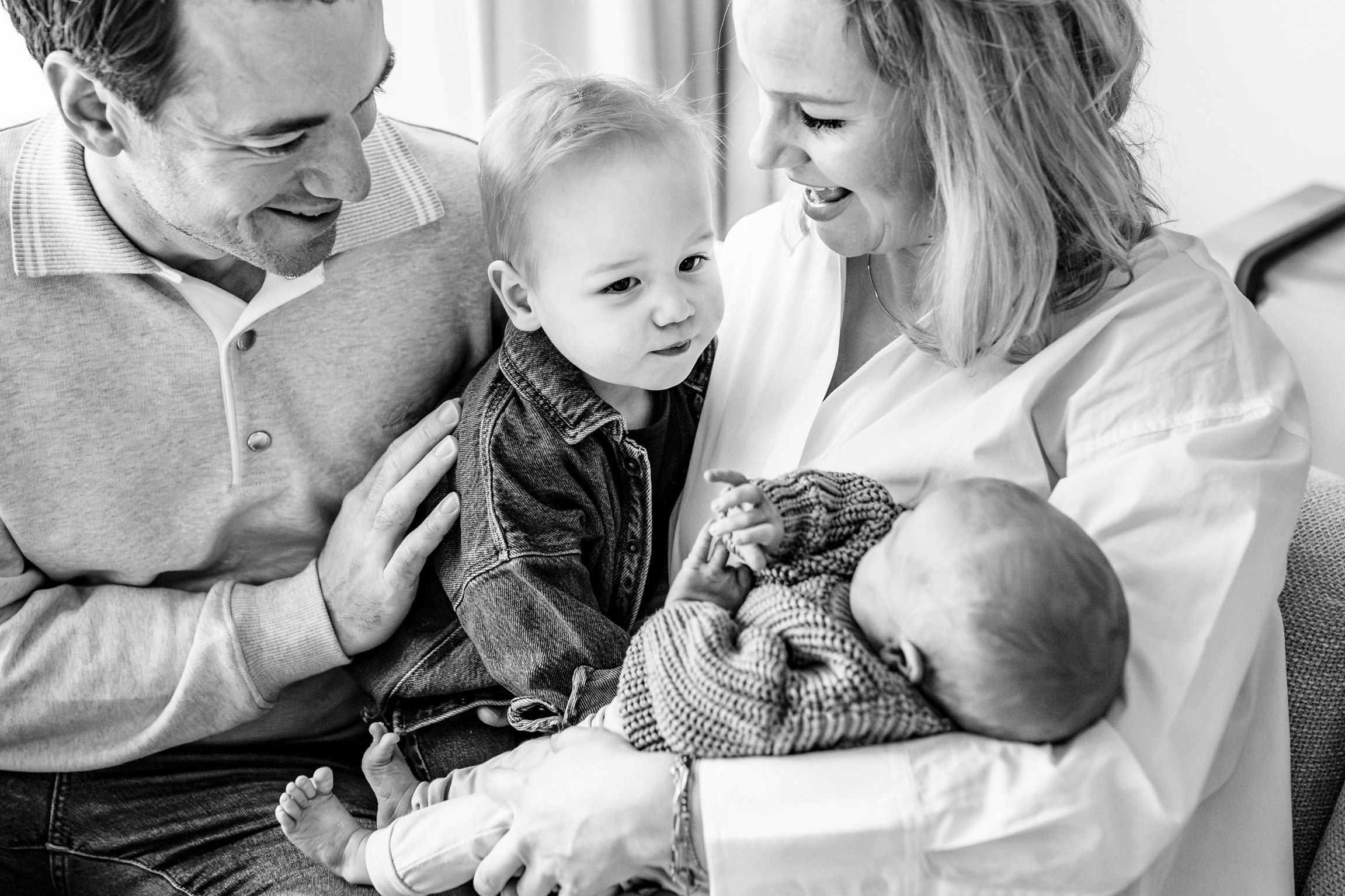 Lifestyle newborn fotoshoot thuis in de Zaanstreek met papa, mama, peuter en baby, zwart-wit portret door Luzan Veenendaal Fotografie