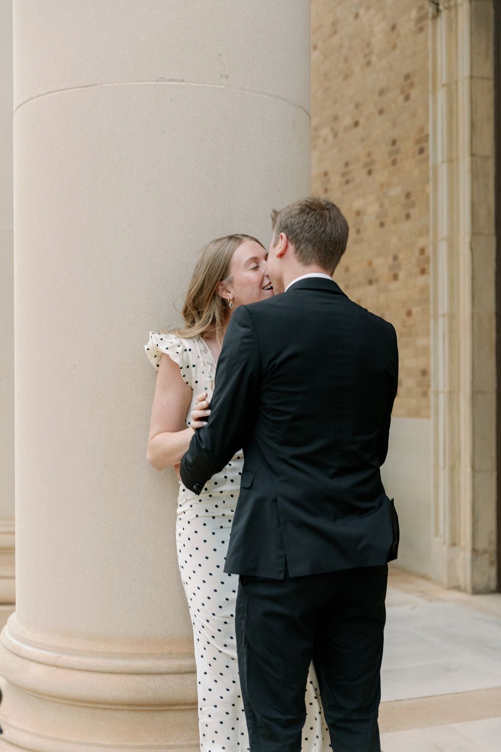 A romantic sequence showing a couple embracing and kissing near classical architecture columns.
