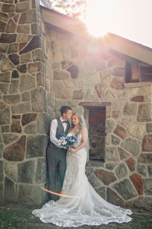 Romantic wedding portraits against a rustic stone wall with beautiful natural lighting.