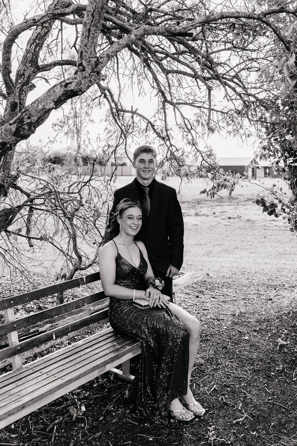 Couple sitting on a chair at formal photo shoot in black and white