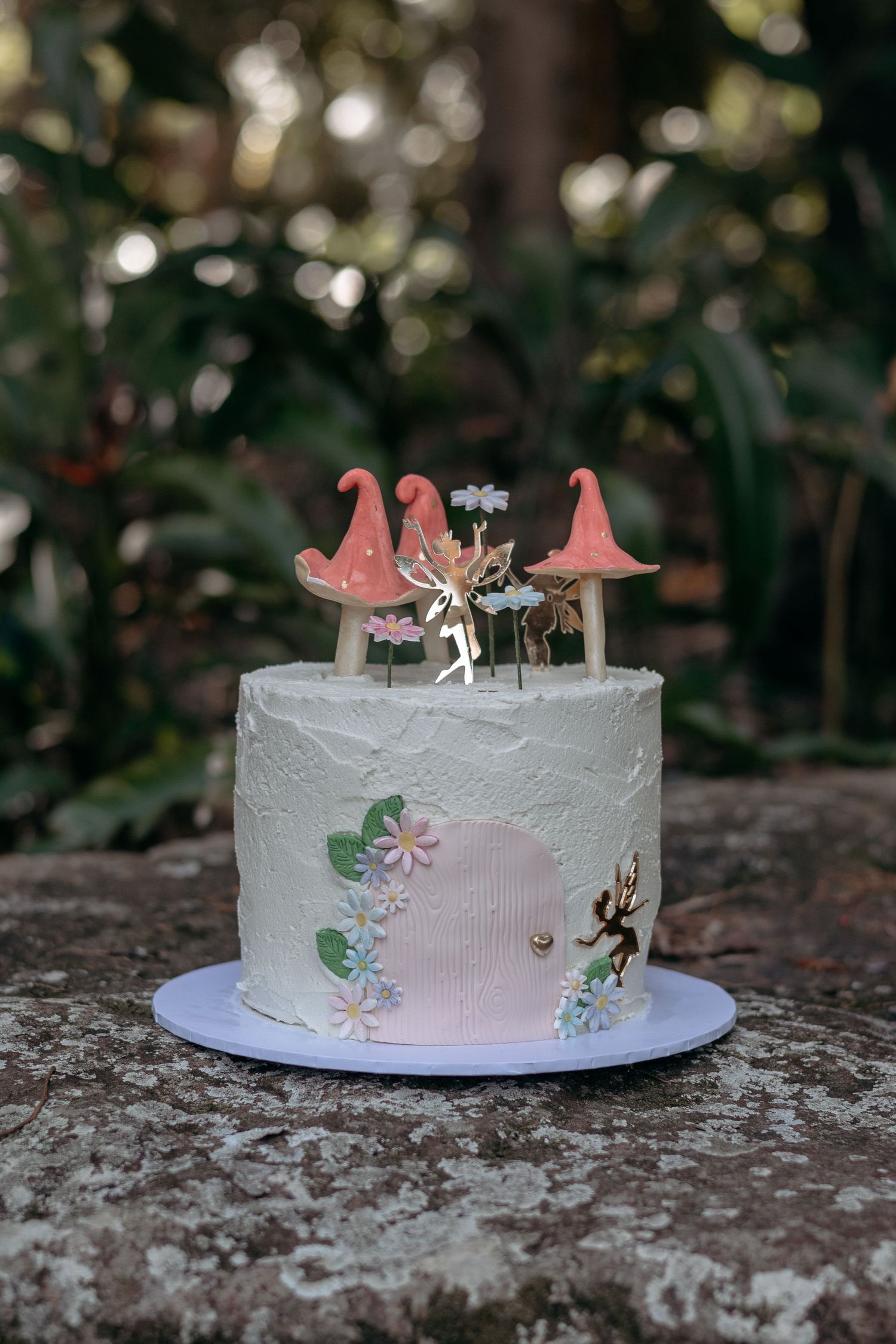 Fairy-inspired cake for a first birthday cake smash in a garden setting