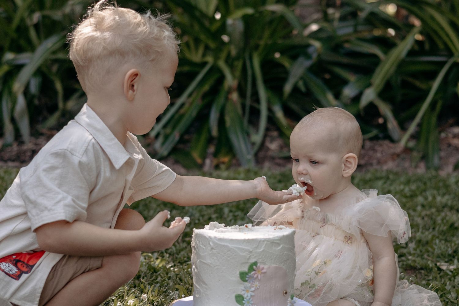 A little girl and her brother are enjoying some cake