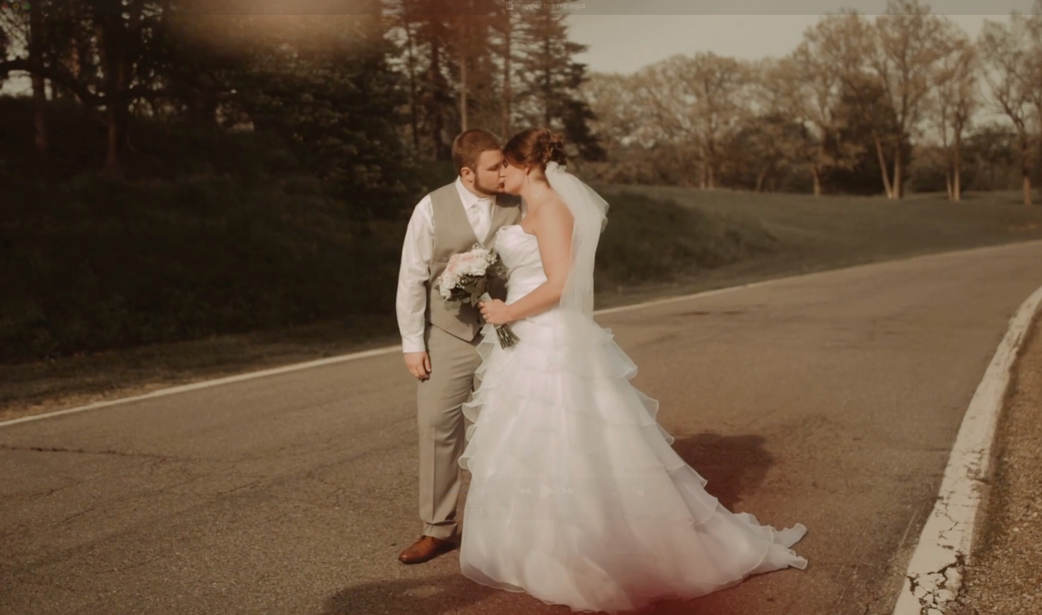 A romantic couple in wedding attire sits together on stone steps during a sunset photoshoot.