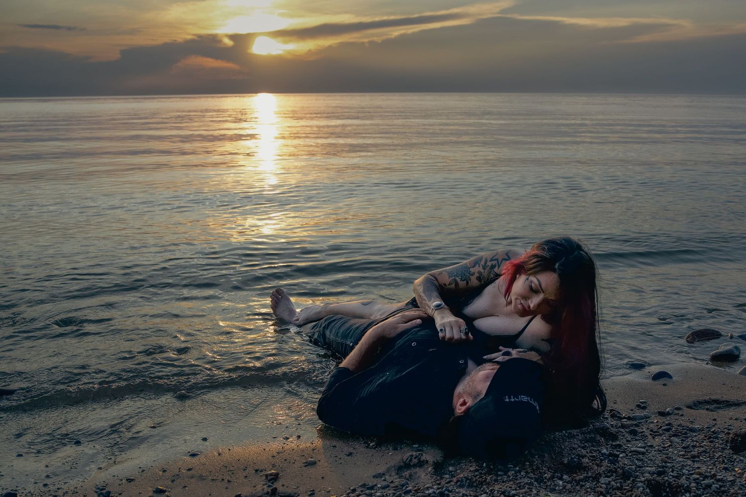 A beautiful sunset over calm ocean waters creates a serene and reflective scene on the shoreline.