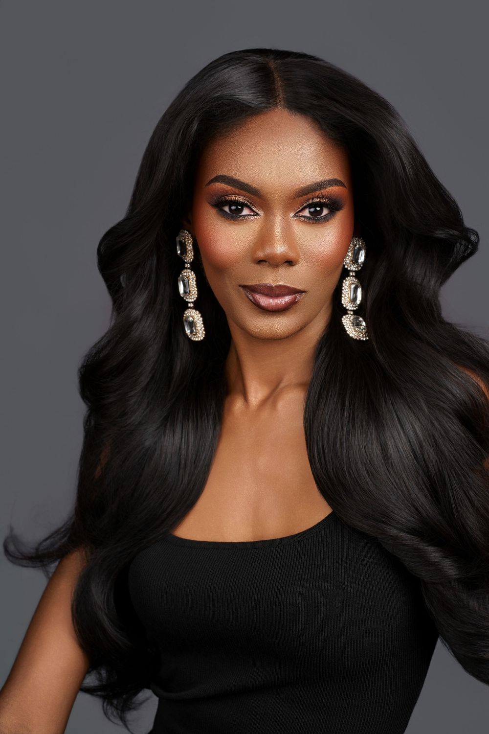 A glamorous beauty portrait series featuring flowing black hair, dramatic makeup and statement earrings against a dark background.