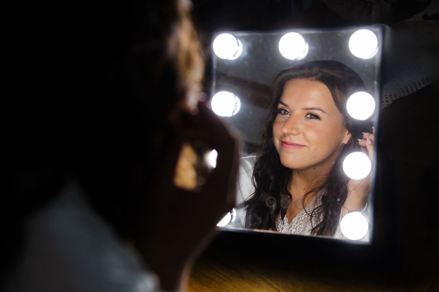 Bride looking into vanity mirror as she get ready for her wedding in Northeast Ohio.