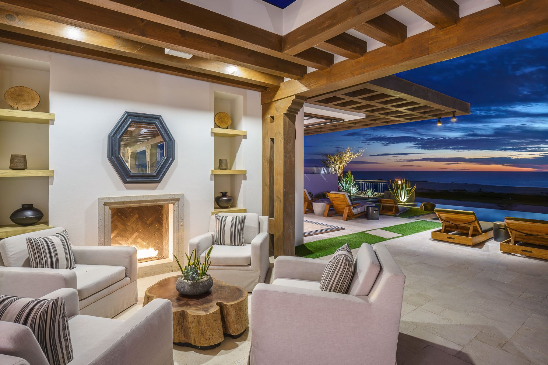 Modern luxury living room with exposed wooden beams, plush seating, and contemporary desert-inspired decor.