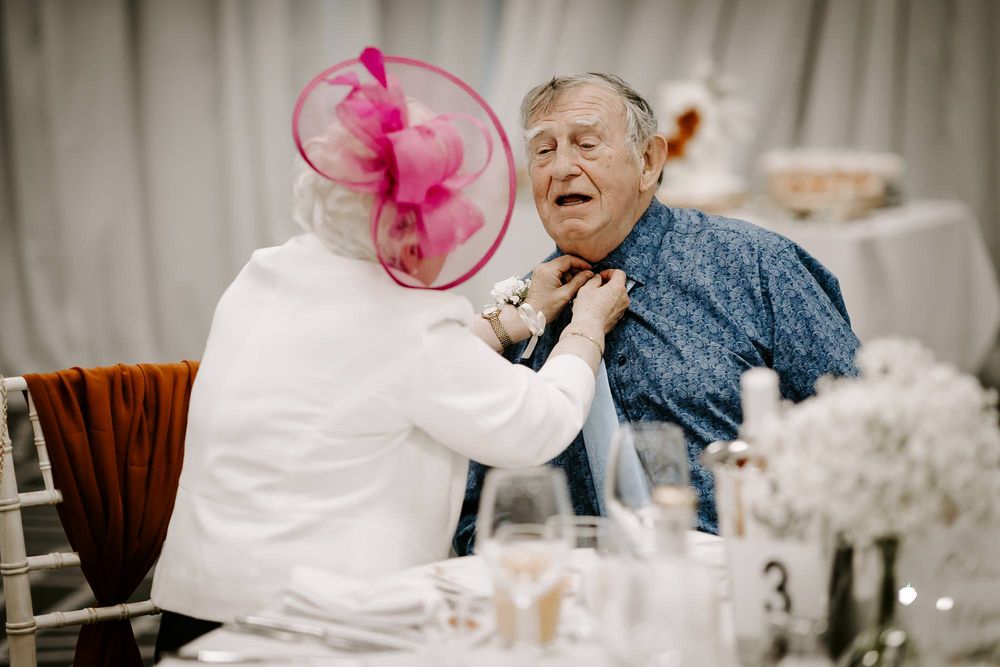 A heartwarming moment shared between two guests at an elegant table setting during a celebration.