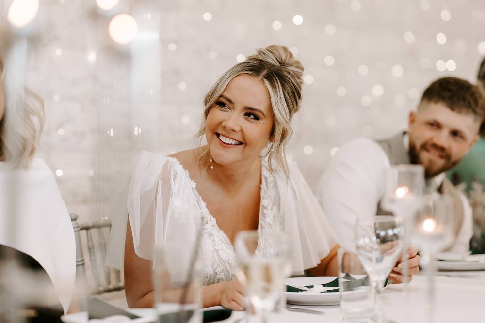 A series of candid wedding reception photos showing guests dining and celebrating at elegant white-decorated tables.
