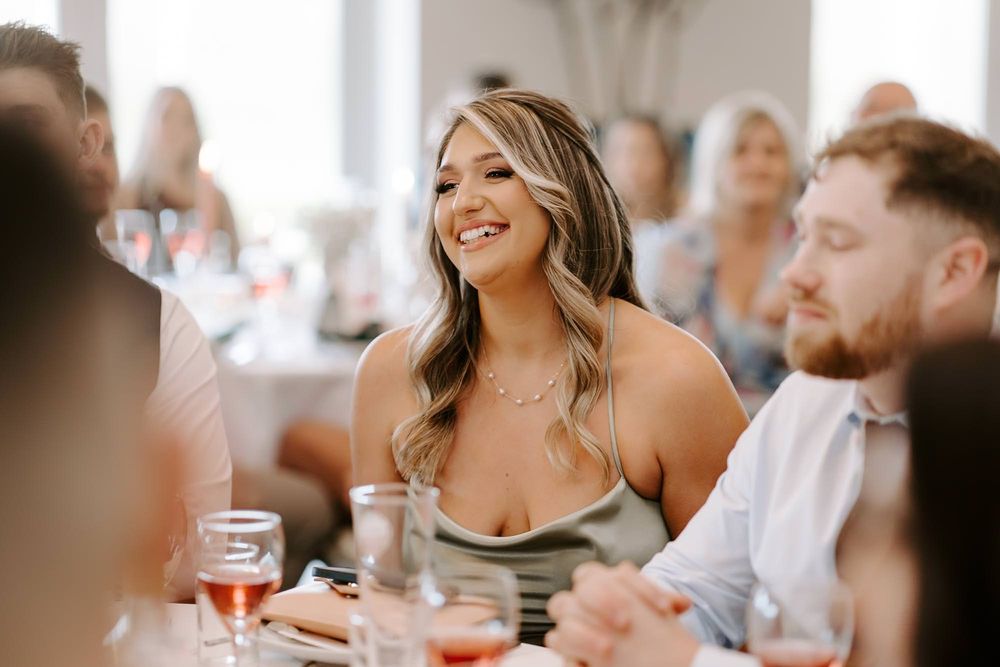 People gathered around a table at a restaurant share laughter and conversation during a social dining experience.