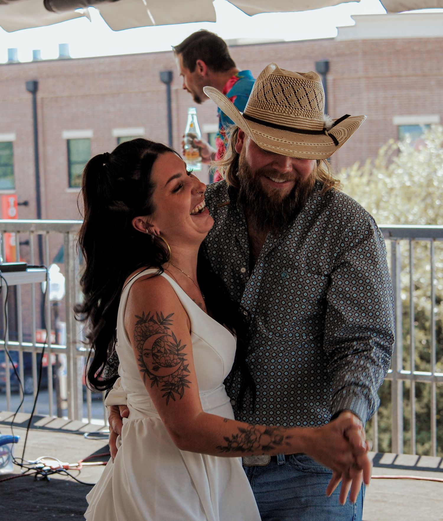 A couple sharing playful and intimate moments together on a balcony while wearing casual attire.