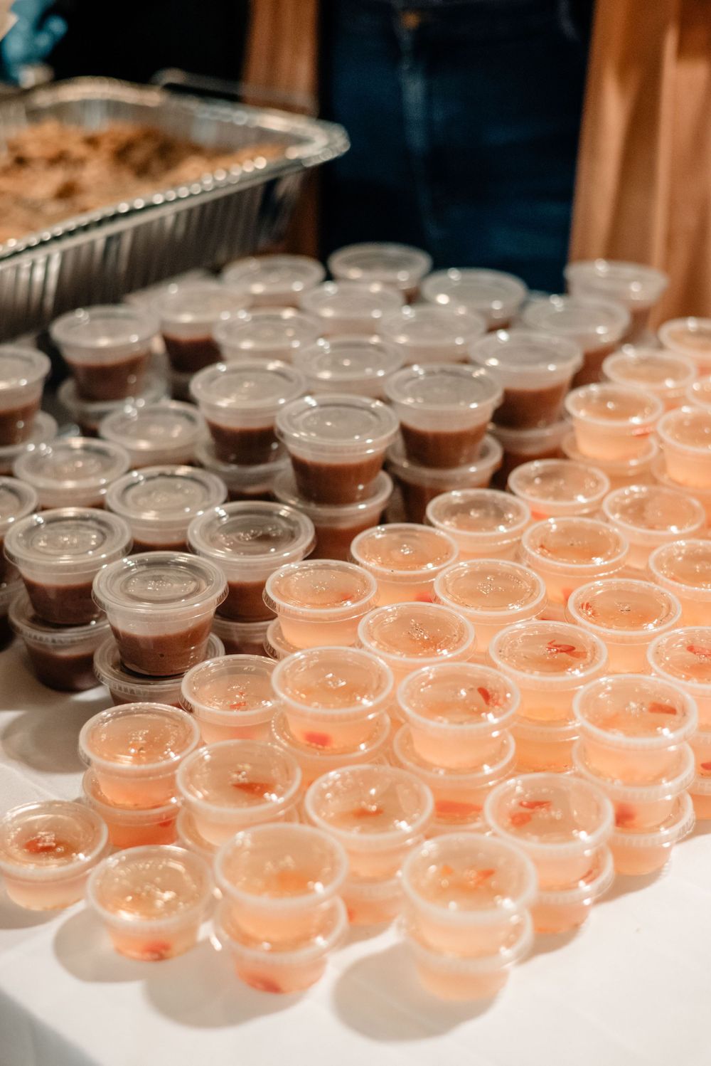 Rows of champagne and cocktail glasses arranged on a catering table.