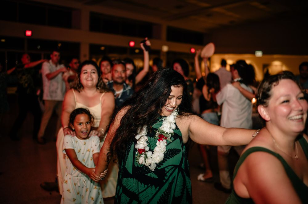 Lively dance floor scene at wedding reception with guests celebrating.
