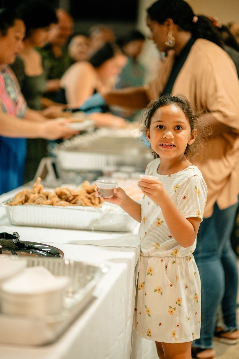 Buffet line at a catered event with people serving food.