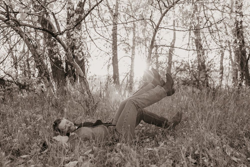Western Couple in Pray, Montana playful playing in Montana Fall leaves. Captured by Montana Photographer