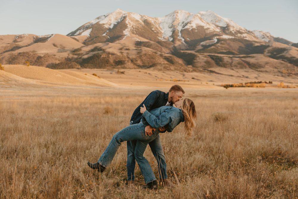 A western couple dip kissing under the mountains of Pray, Montana. Captured by a Montana wedding photographer in Paradise Valley.