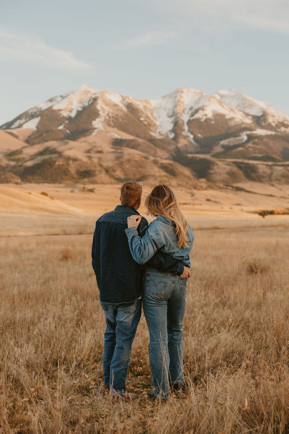 Montana couple looking off into the mountains during their engagement photos in their western Cowboy tuxedo outfits, in Paradise Valley