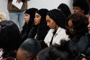 Audience members gathered closely together at an indoor event.