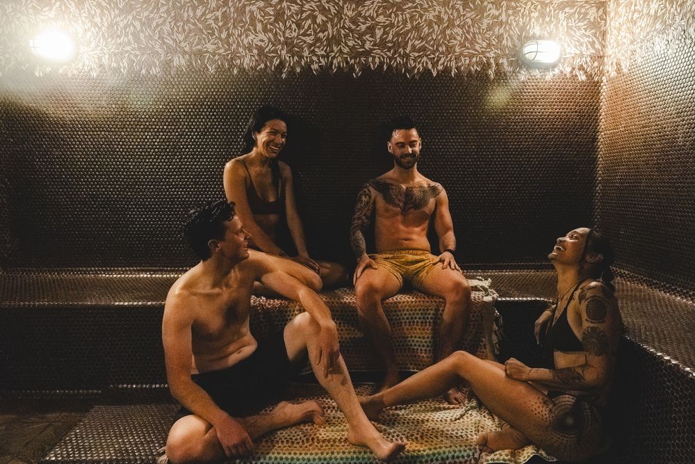 Athletes rest and recover on mats after an intense training session in a dimly lit gym.