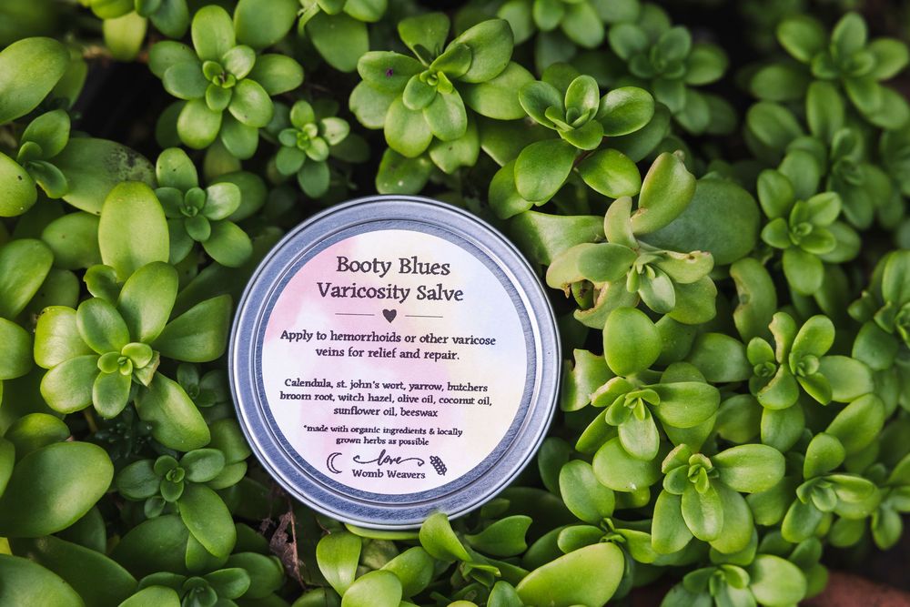 Green succulent plants provide natural background with beauty product jars visible in corner of frame.