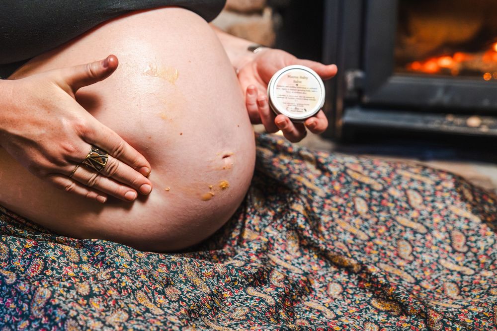 A close-up view of hands holding a pregnancy test stick against a floral patterned background.